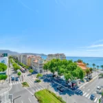 Vue plongeante sur une avenue de Nice jusqu’à la mer, depuis un appartement géré par Hello Riviera Stay