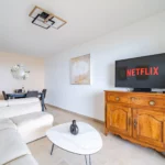 Salon avec canapé d’angle et télévision, appartement face à la mer à Villeneuve-Loubet
